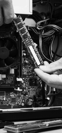 Black and white photo showing hands that are making a motherboard