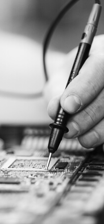 Black and white photo showing a hand with soldering iron