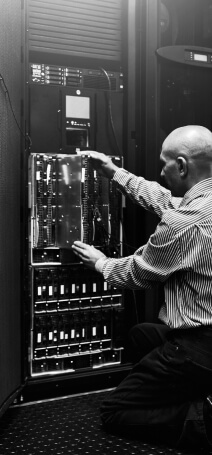 Black and white photo showing a man managing a server